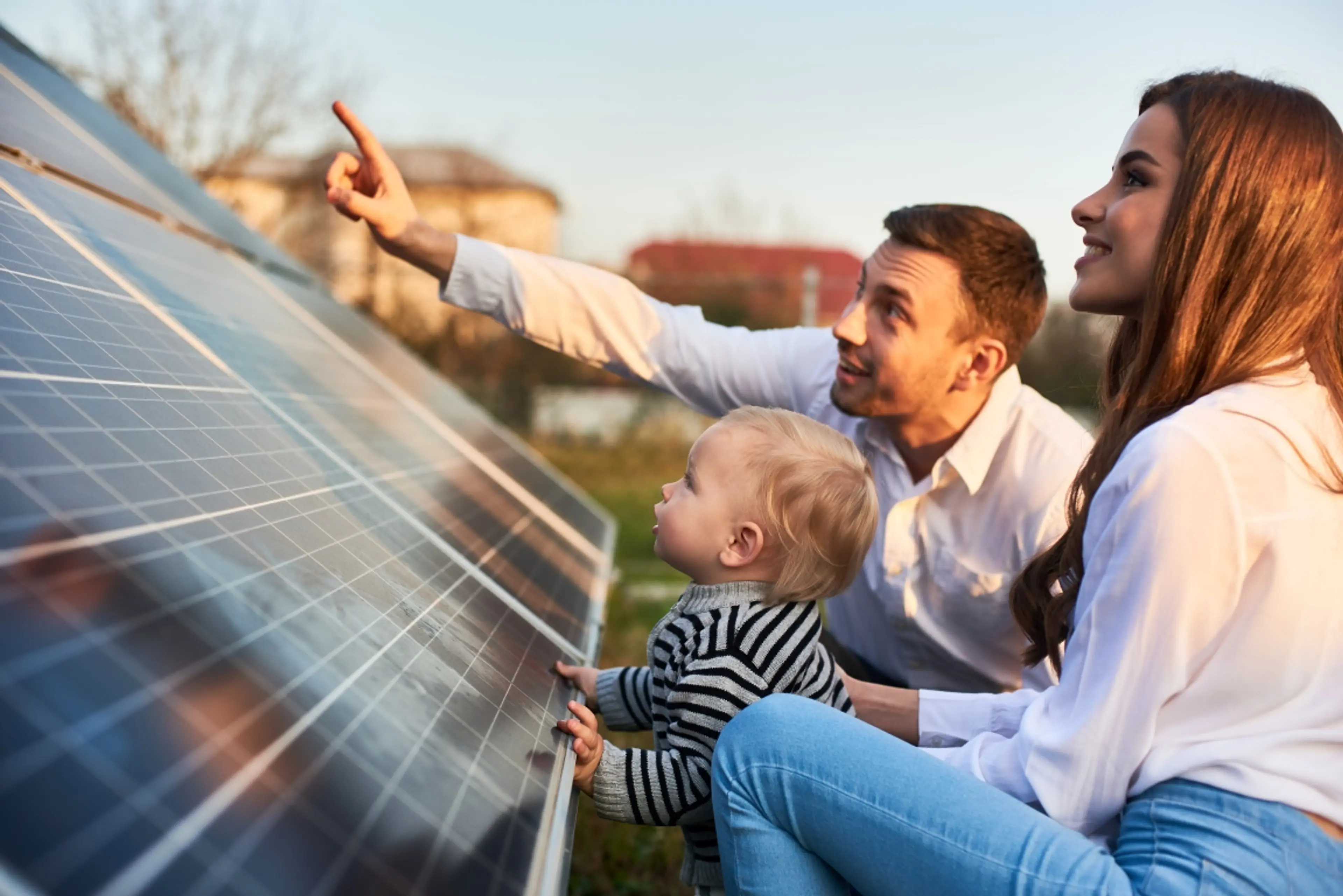 Kleine Familele schaut auf Solaranlage-Module 