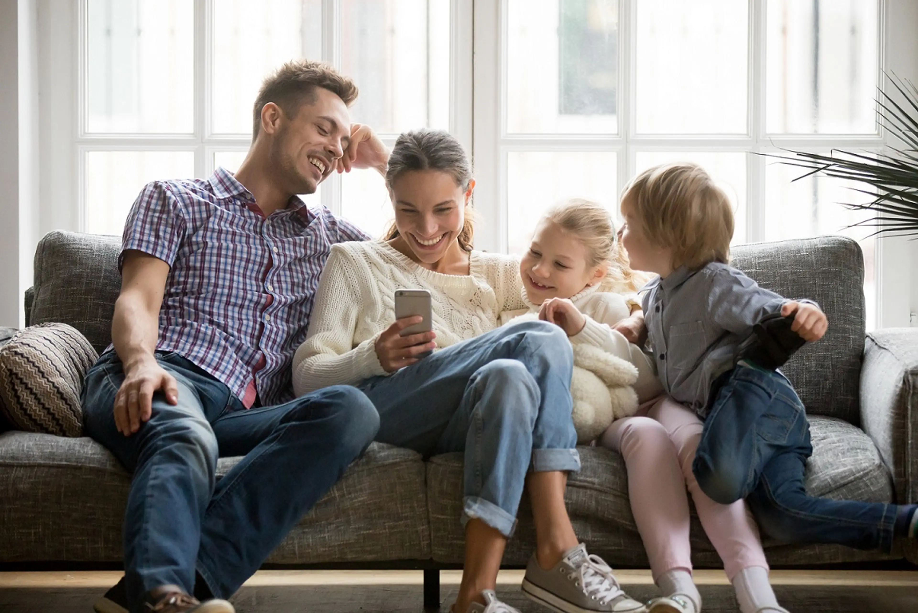 Familie auf dem Sofa mit einem Smartphone