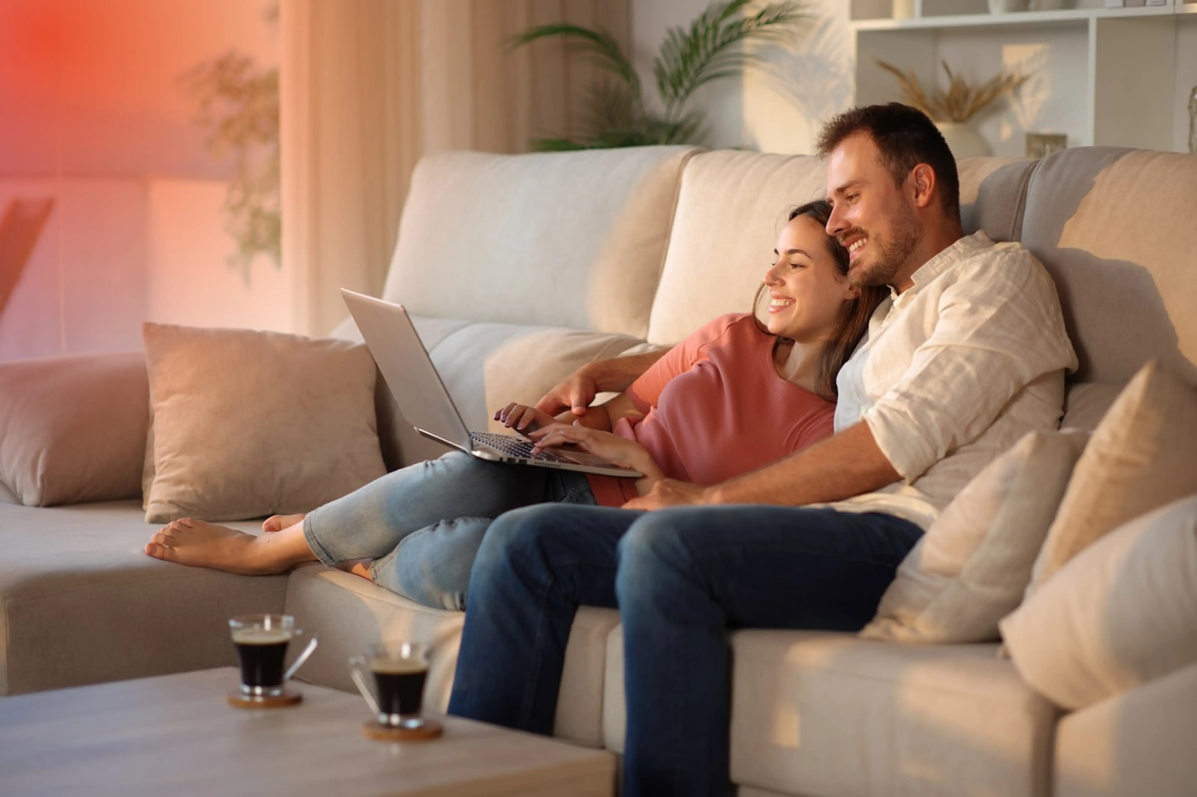Ein Mann und eine Frau sitzten glücklich auf dem Sofa