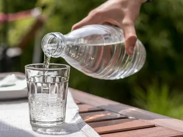 Trinkwasser wird aus einer Flasche in ein glas gefüllt